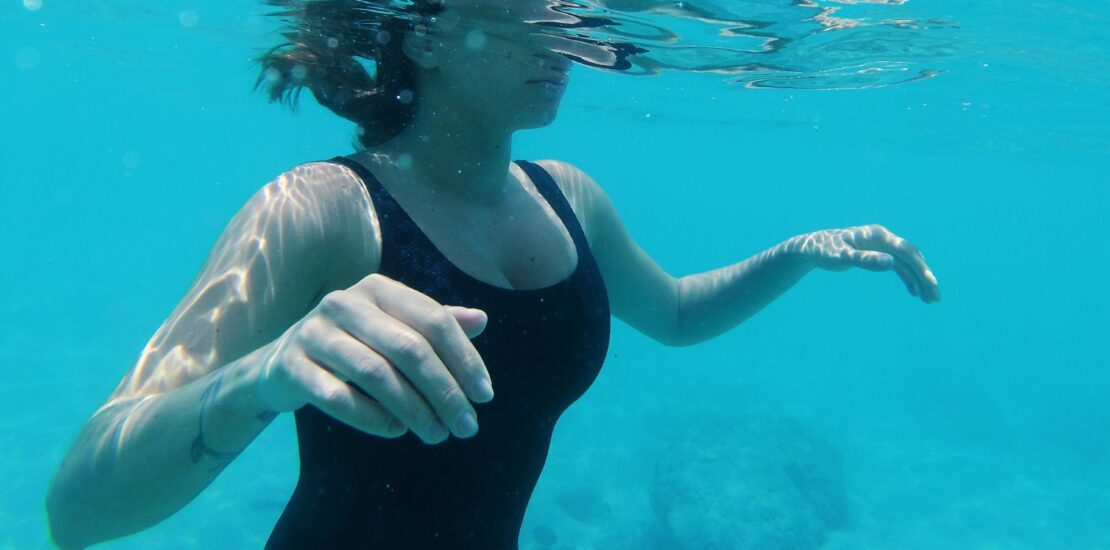 Woman underwater practising breath control during swimming session