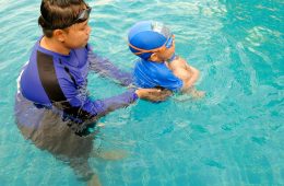 "Building water confidence — a child learns to swim with the guidance of an instructor."